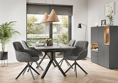Modern dining room with a minimalist design featuring a stylish dark wood table, gray upholstered chairs, pendant lights, and a sleek sideboard.
