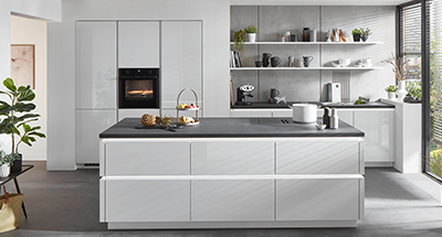 Moderne keuken met witte kasten, roestvrijstalen apparaten, zwevende planken en een minimalistische esthetiek.