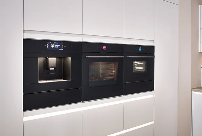 Moderne Kompaktgeräte mit integrierter Kaffeemaschine in einer nobilia Küche mit Front SENSO 490 in Alpinweiß Premium matt. Perfekte Kombination aus Funktion und Design für anspruchsvolle Küchennutzung.