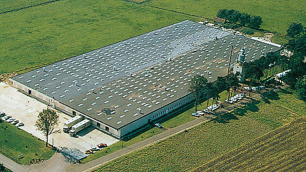 Luftansicht des nobilia Werkes mit flachem Dach und vielen Lichtkuppeln im Jahr 1970, umgeben von Feldern und Bäumen.