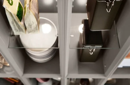 Offenes Regalsystem mit Glaseinlegeböden zur stilvollen Aufbewahrung von Geschirr und Vorratsdosen in modernem Design.