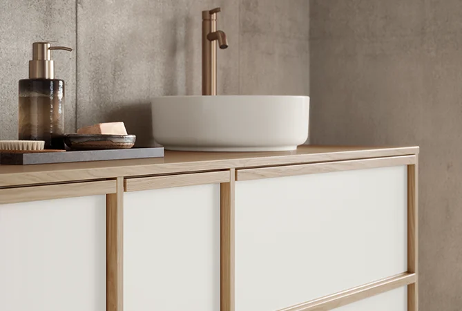 Stilvolles Badmöbel im Japandi-Look mit bronzefarbener Armatur & harmonischem Zubehör in Holzrahmenoptik.