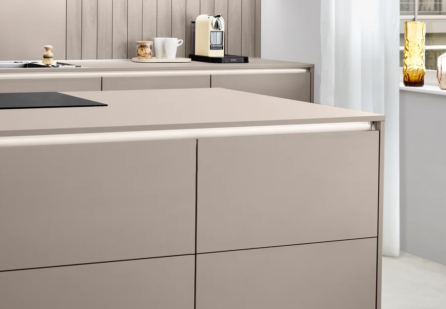 Grifflose Kücheninsel mit LINE One Fronten in Taupe, ausgestattet mit Push-to-open Funktion für eine ruhige, durchgängige Linienführung.