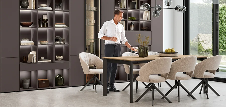 Moderner Essbereich mit Sessel TURN II – stilvoll, bequem und perfekt kombiniert mit offenen Wohnregalen und stimmungsvoller Beleuchtung.