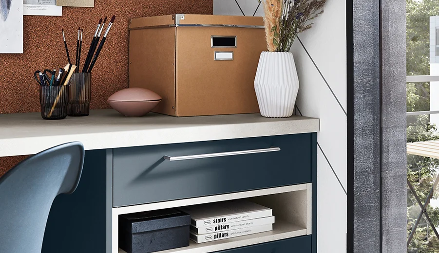 Easytouch (966) / Beton Sand Nachbildung (201) Zeitgemäßes Homeoffice mit einem eleganten blauen Schreibtisch mit organisierten Regalen, stilvollen Aufbewahrungsboxen und dekorativen Gegenständen, die Funktionalität mit moderner Ästhetik verbinden.